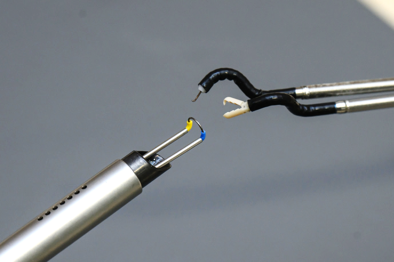 Conventional resection loop used to perform bladder tumour resection (left) versus the pair of flexible robotic instruments developed by Agilis Robotics (right).