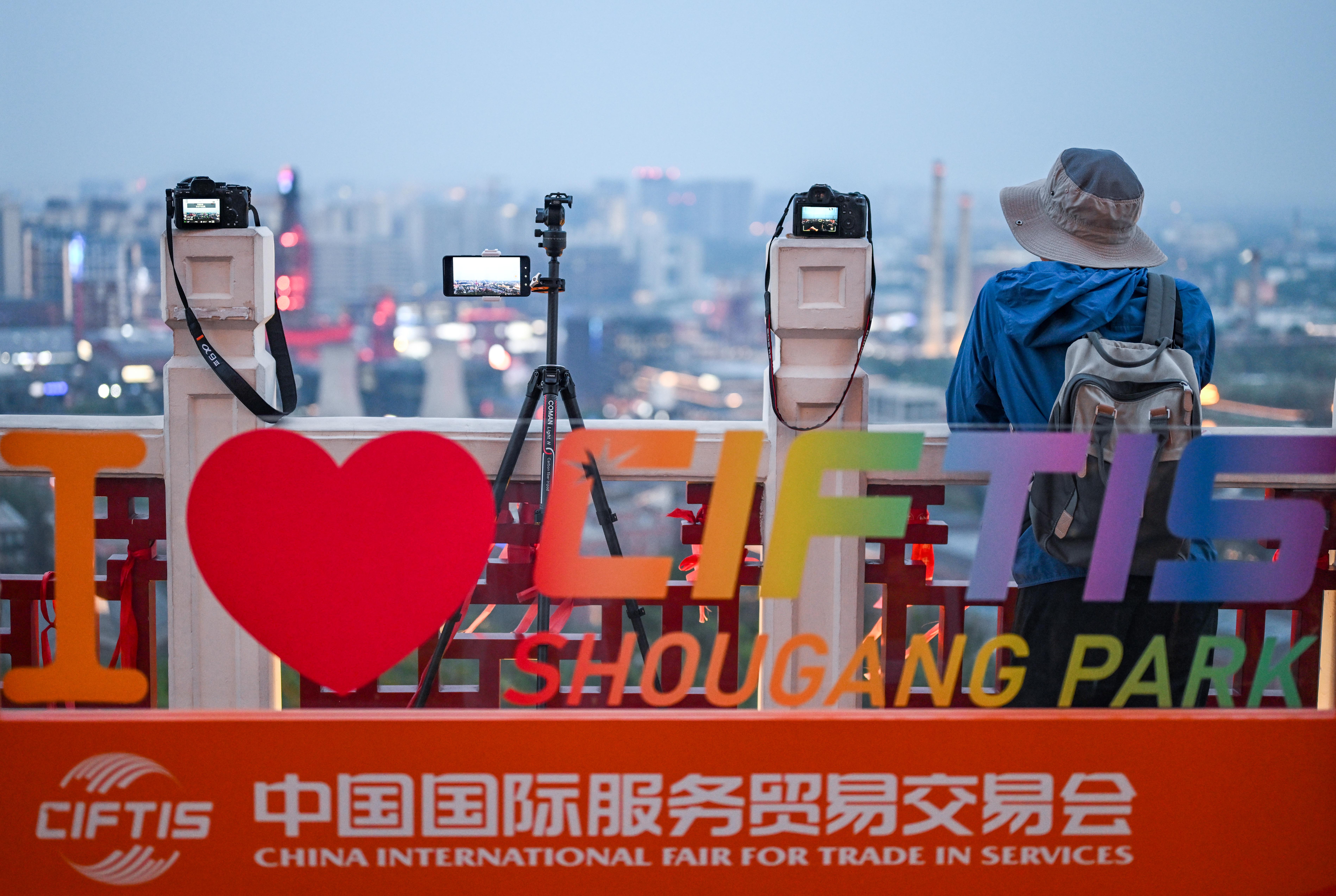 Caption: This photo taken on Sept. 11, 2025 shows a photography enthusiast taking pictures of the night view of Shougang Park in Beijing, capital of China. Against the backdrop of repurposed blast furnaces and industrial relics of Shougang Park in western Beijing, the 2025 China International Fair for Trade in Services (CIFTIS) opened on Wednesday, striking a tone of open markets and digital innovation. (Xinhua/Chen Yehua)