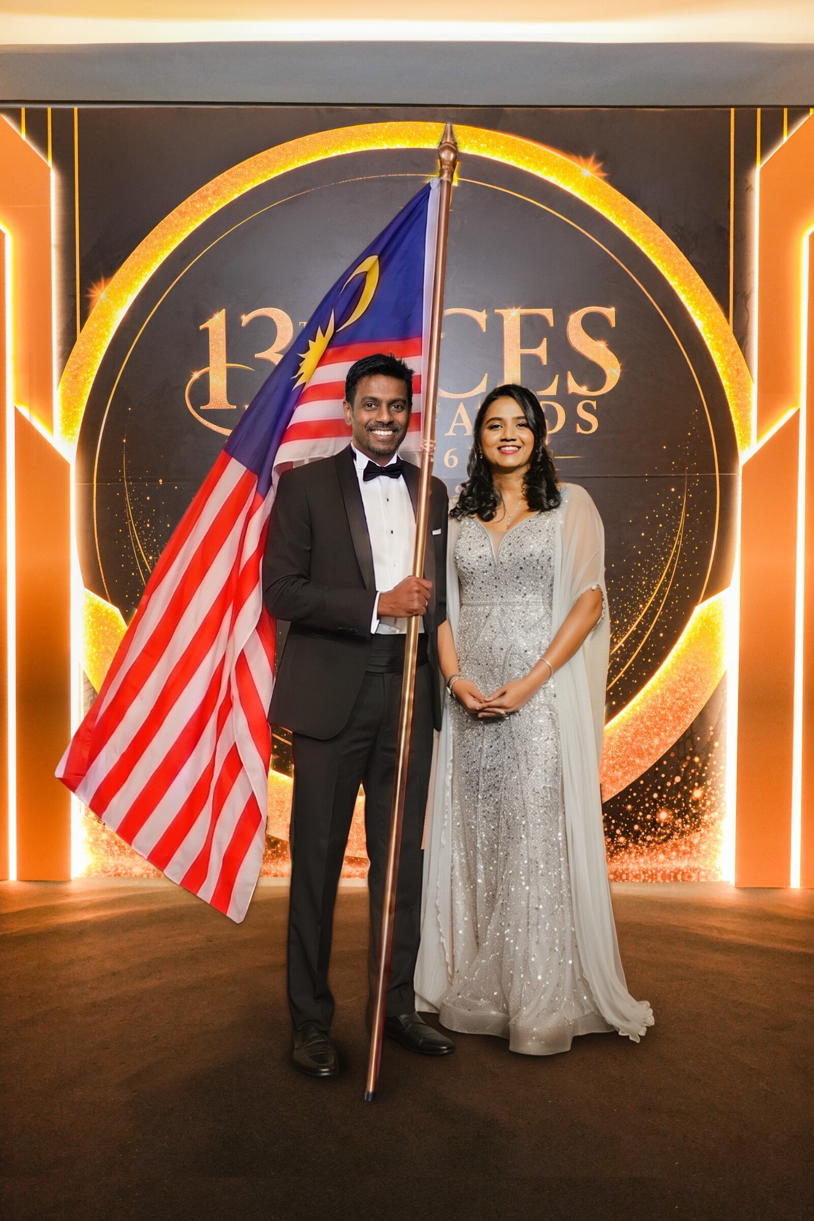 Dr Shanggari Balakrishnan with national badminton coach K. Yogendran, who carried the Jalur Gemilang during the opening of ACES Awards 2026 on 16 October in Kuala Lumpur.